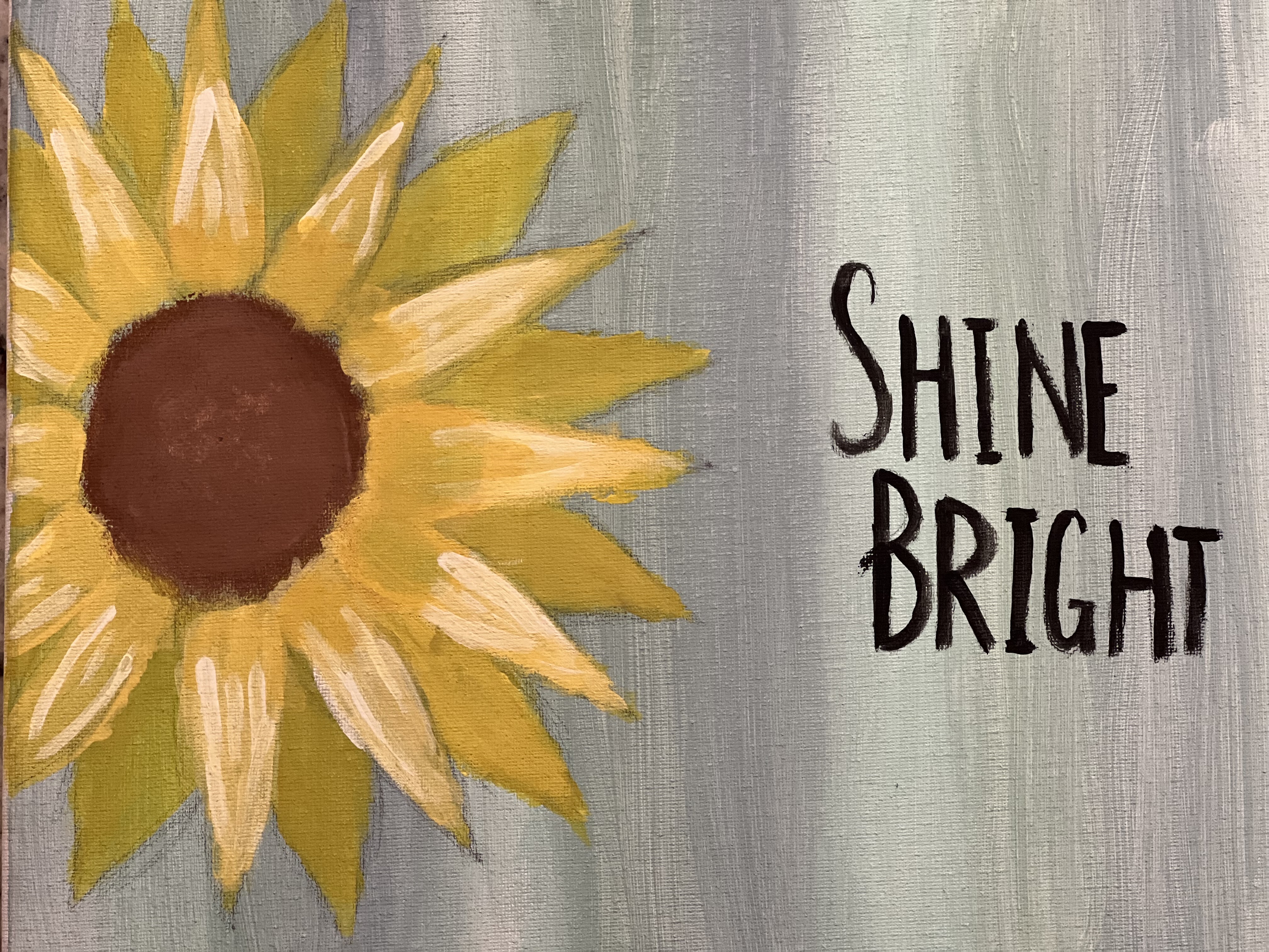A painting with bright sun beams on a gray background with text that reads shine bright
