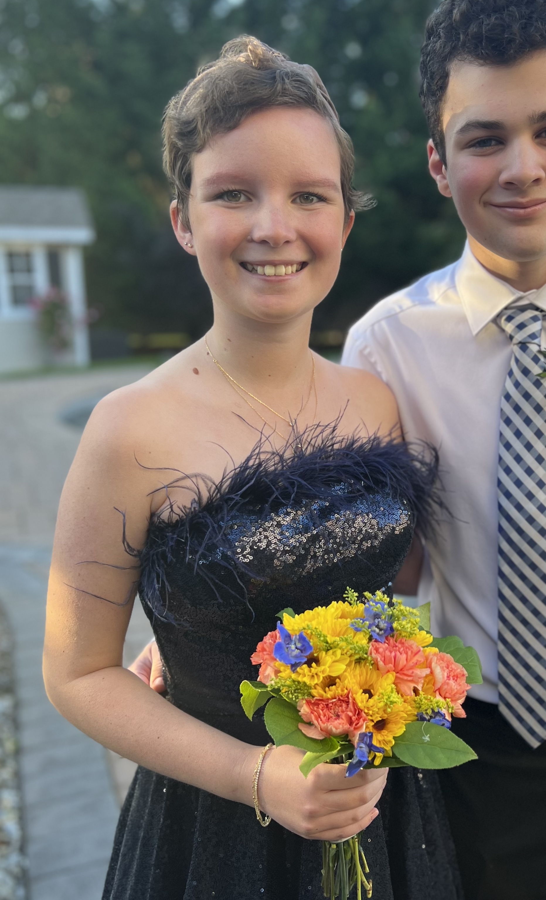 Rylee holding colorful flowers while posing for a formal picture outdoors